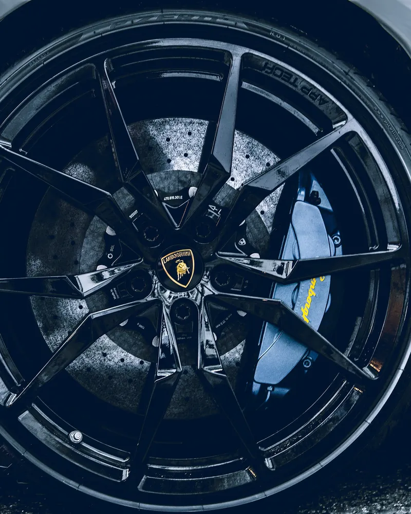 Example photo: a gloss black wheel with a blue brake caliper